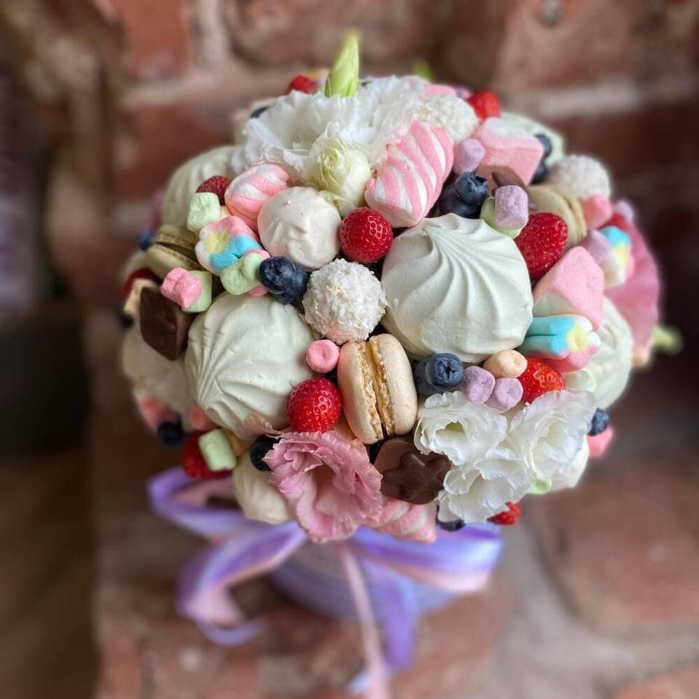Съедобный букет из эустомы, клубники, макаронс, конфет и сладостей в шляпной коробке 